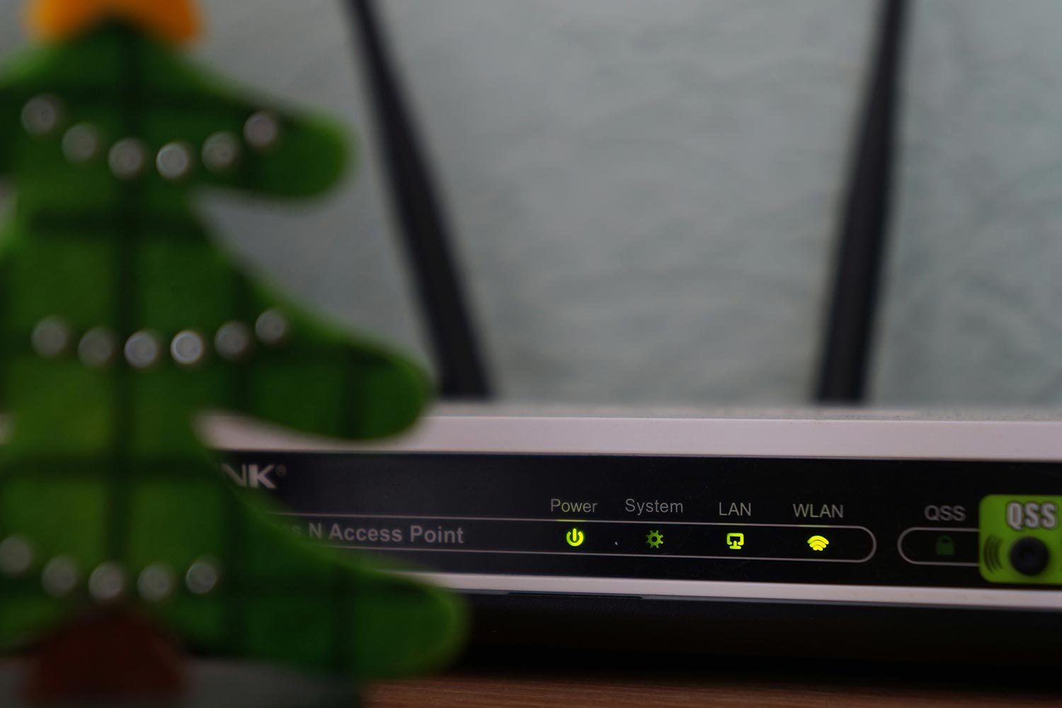 Wireless router with active indicator lights behind blurred holiday decor