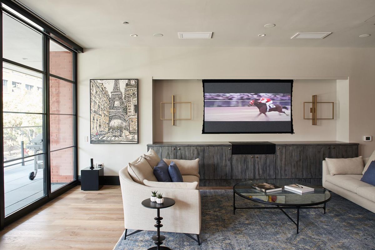 Cozy living room with horse racing on TV and large glass doors