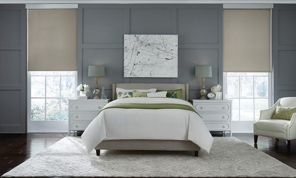 Modern bedroom with automated window shades and soft lighting.