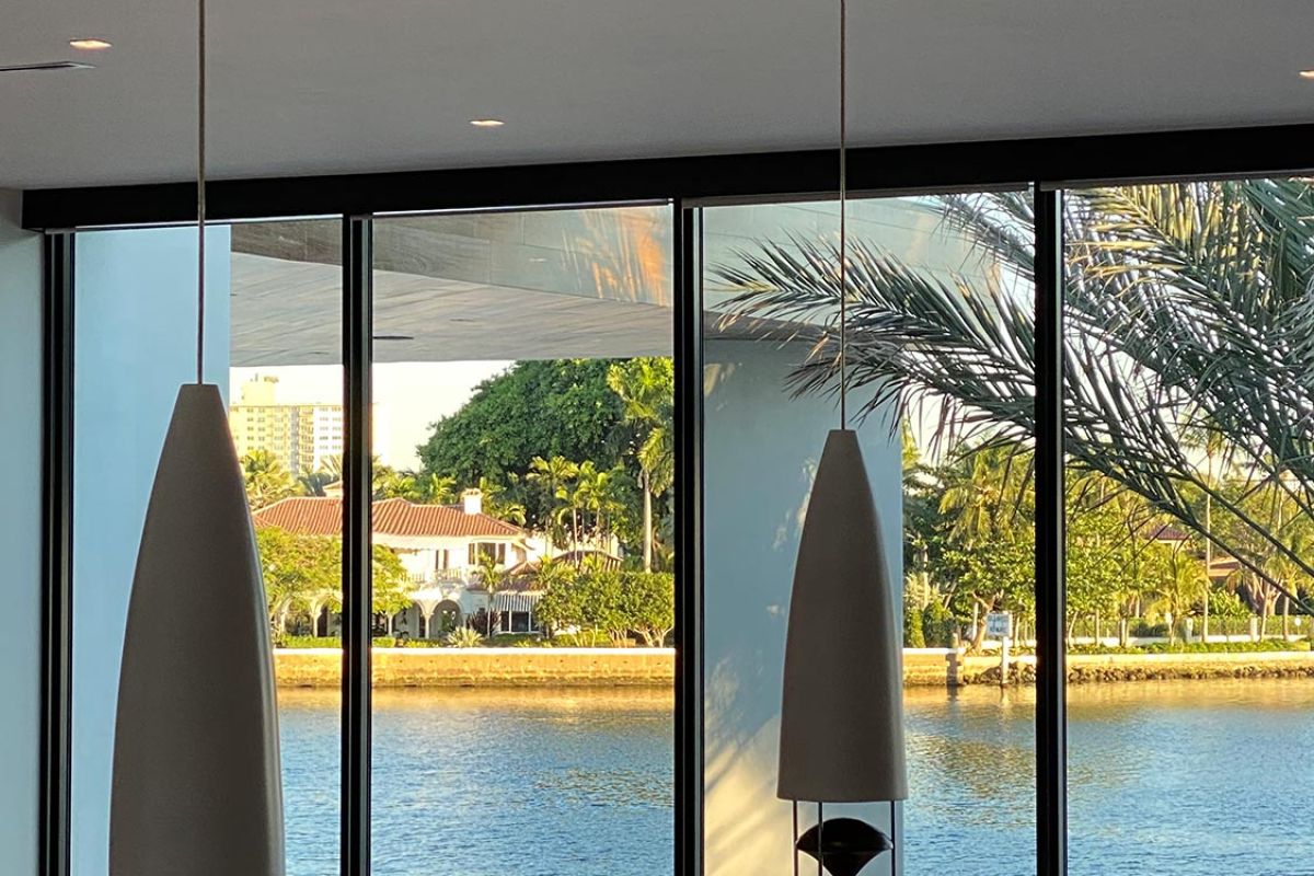 Hanging pendant lights in front of large windows overlooking water