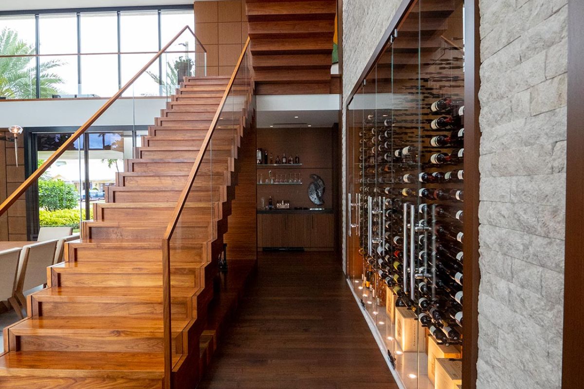 Side view of wood staircase with adjacent wine cellar and bar area