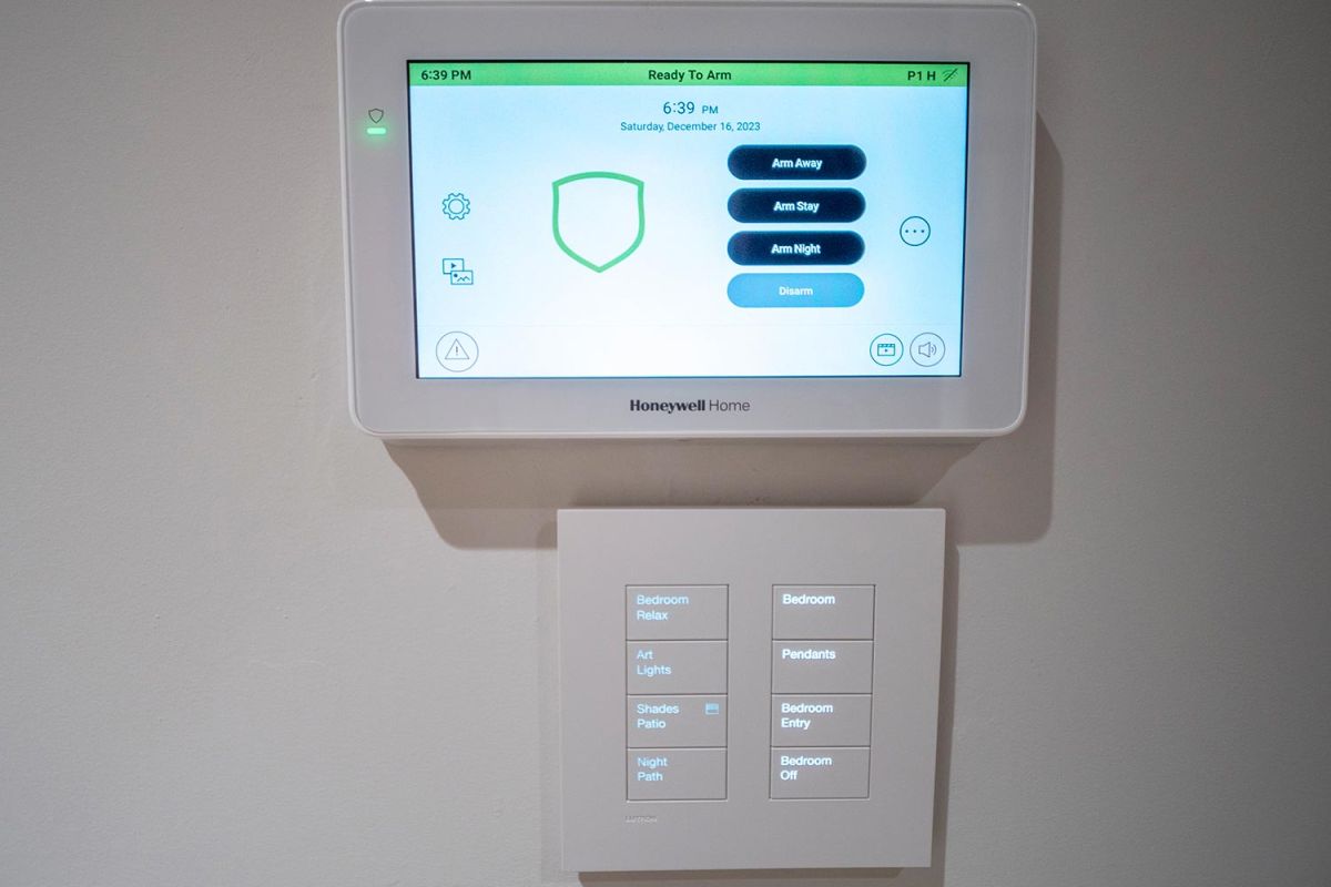 Home security panel above a bedroom lighting control panel