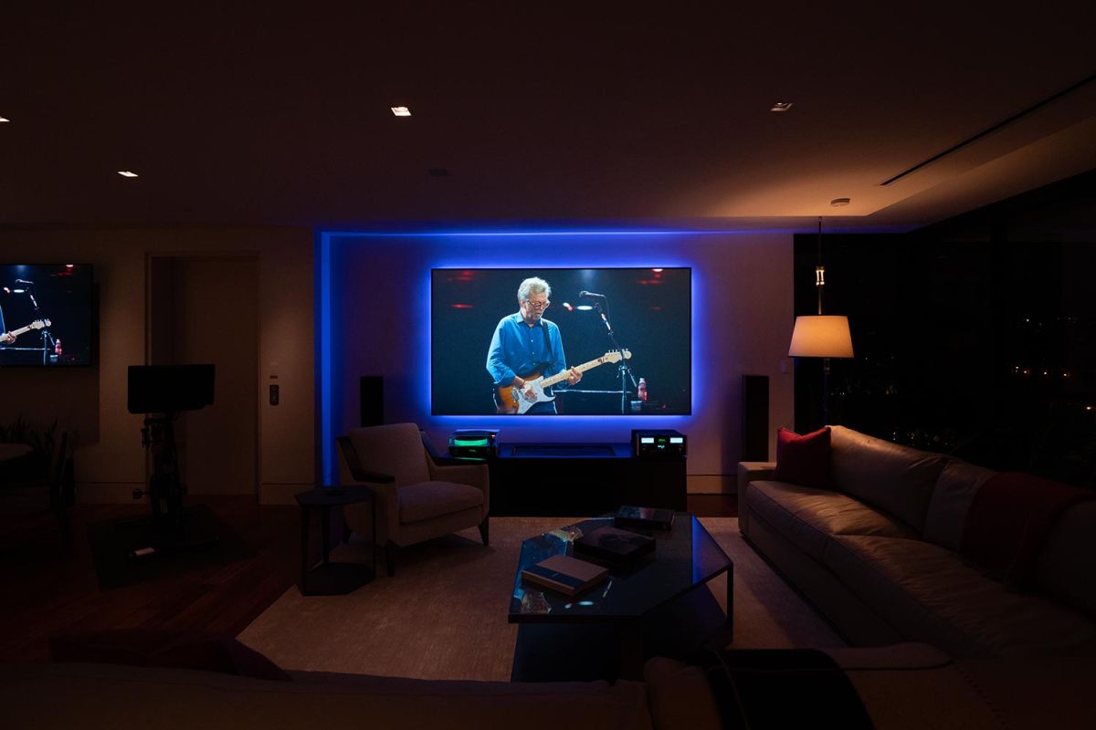 Home theater setup with large screen and ambient blue lighting at night