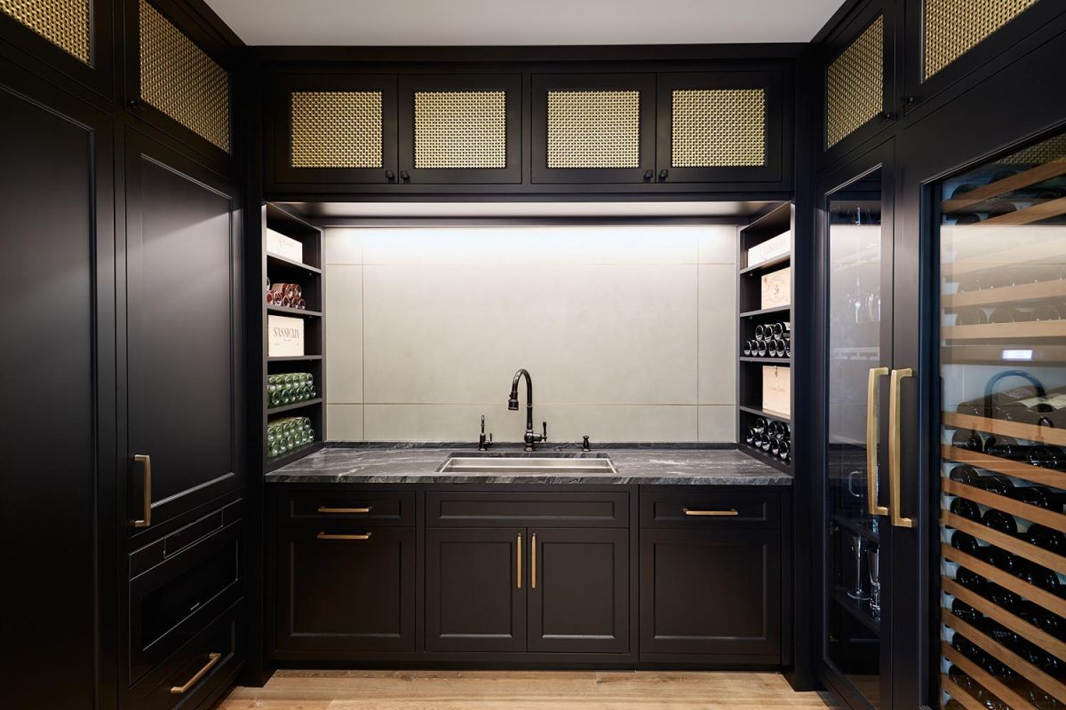 Stylish wet bar with dark cabinetry, sink, and wine refrigerators