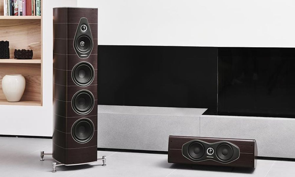 Premium floor-standing speakers and center speaker in a modern living room.