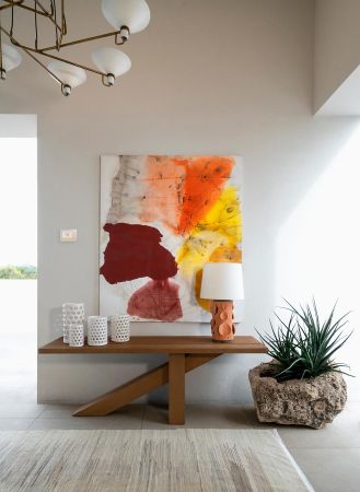 Stylish entryway with a wooden console table and abstract artwork.
