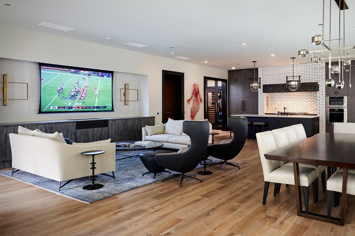 Open concept living space with TV, kitchen, dining, and modern furnishings