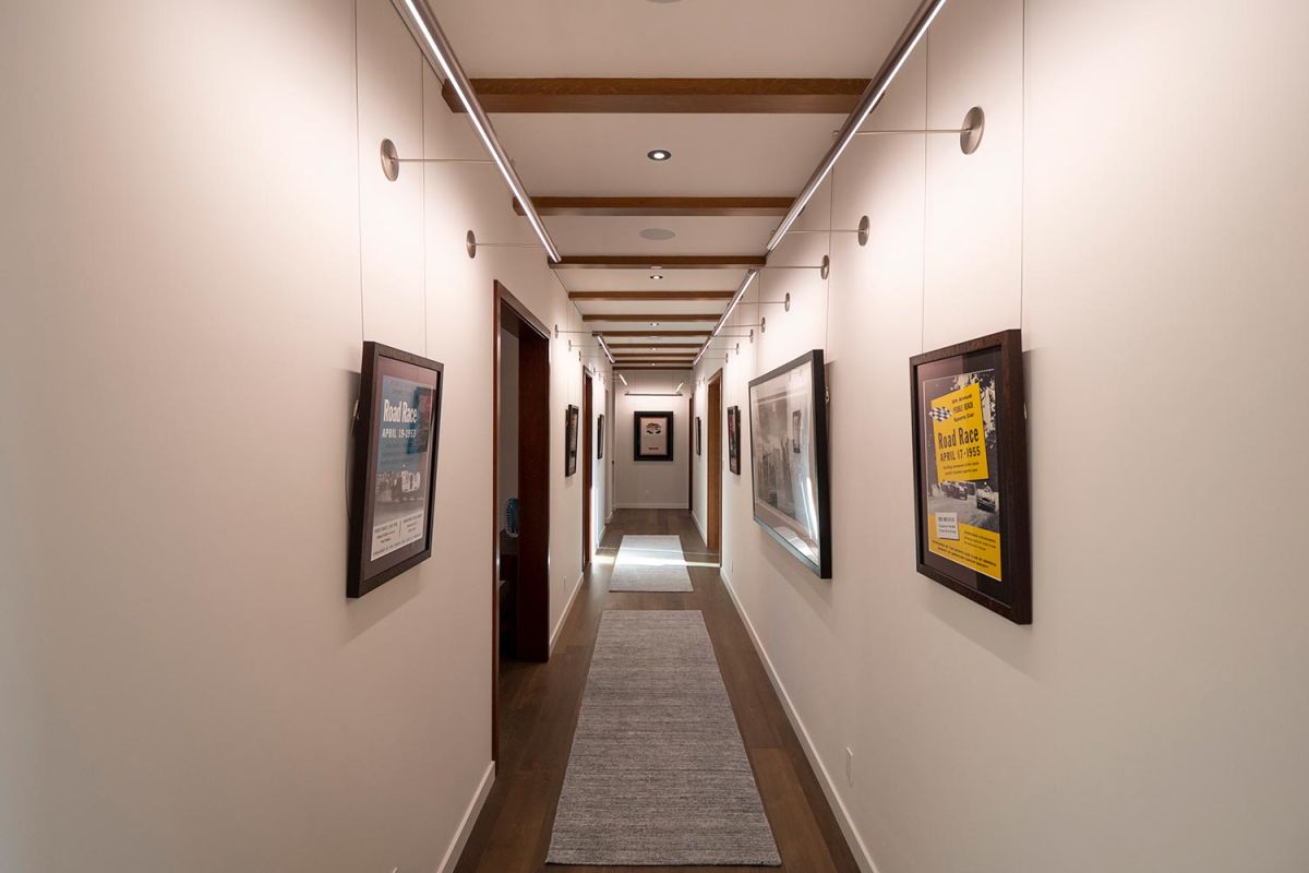 Framed posters and artwork hanging in a well-lit gallery-style hallway